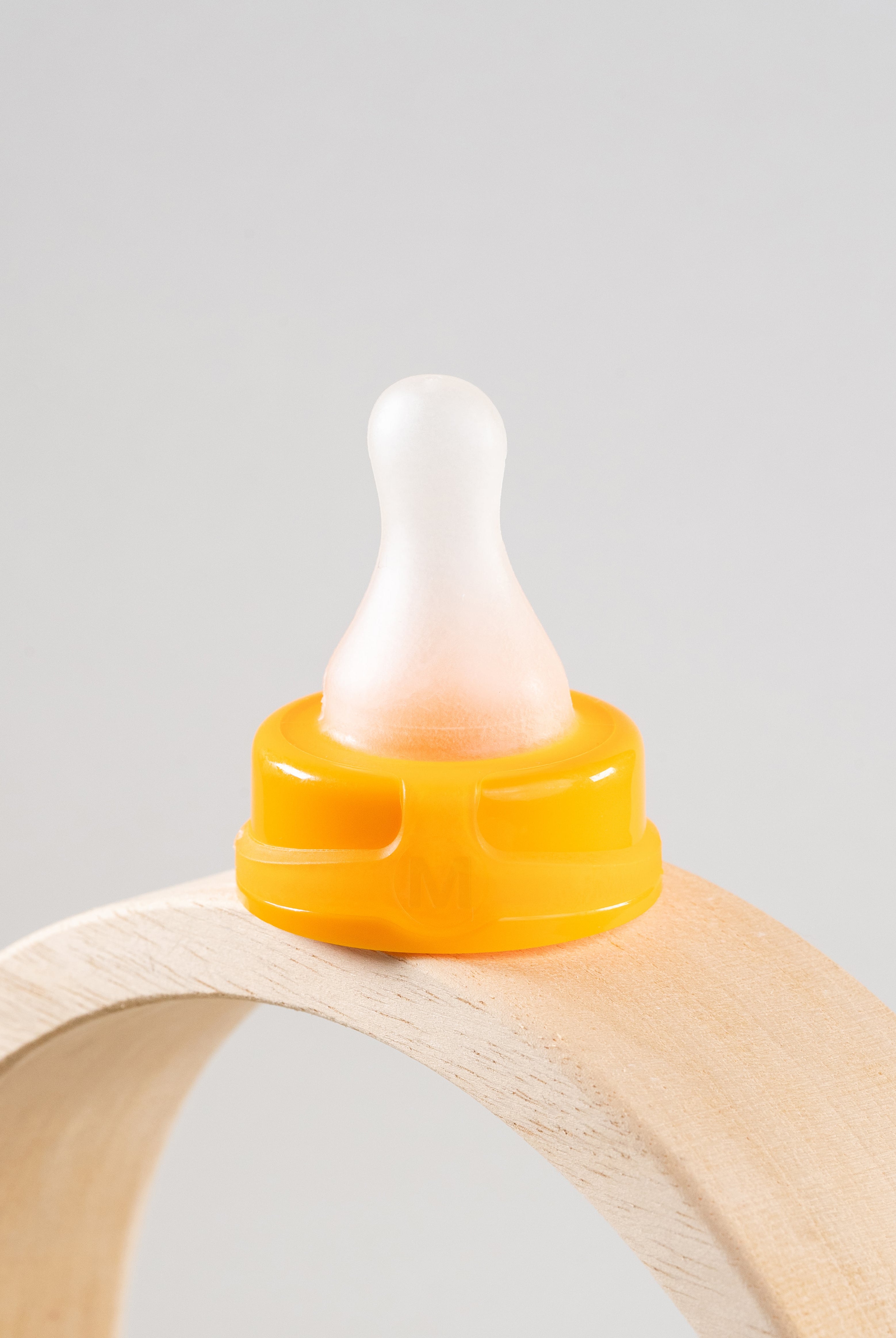 Sepal orange medium teat fast flow displayed on a wooden arch.