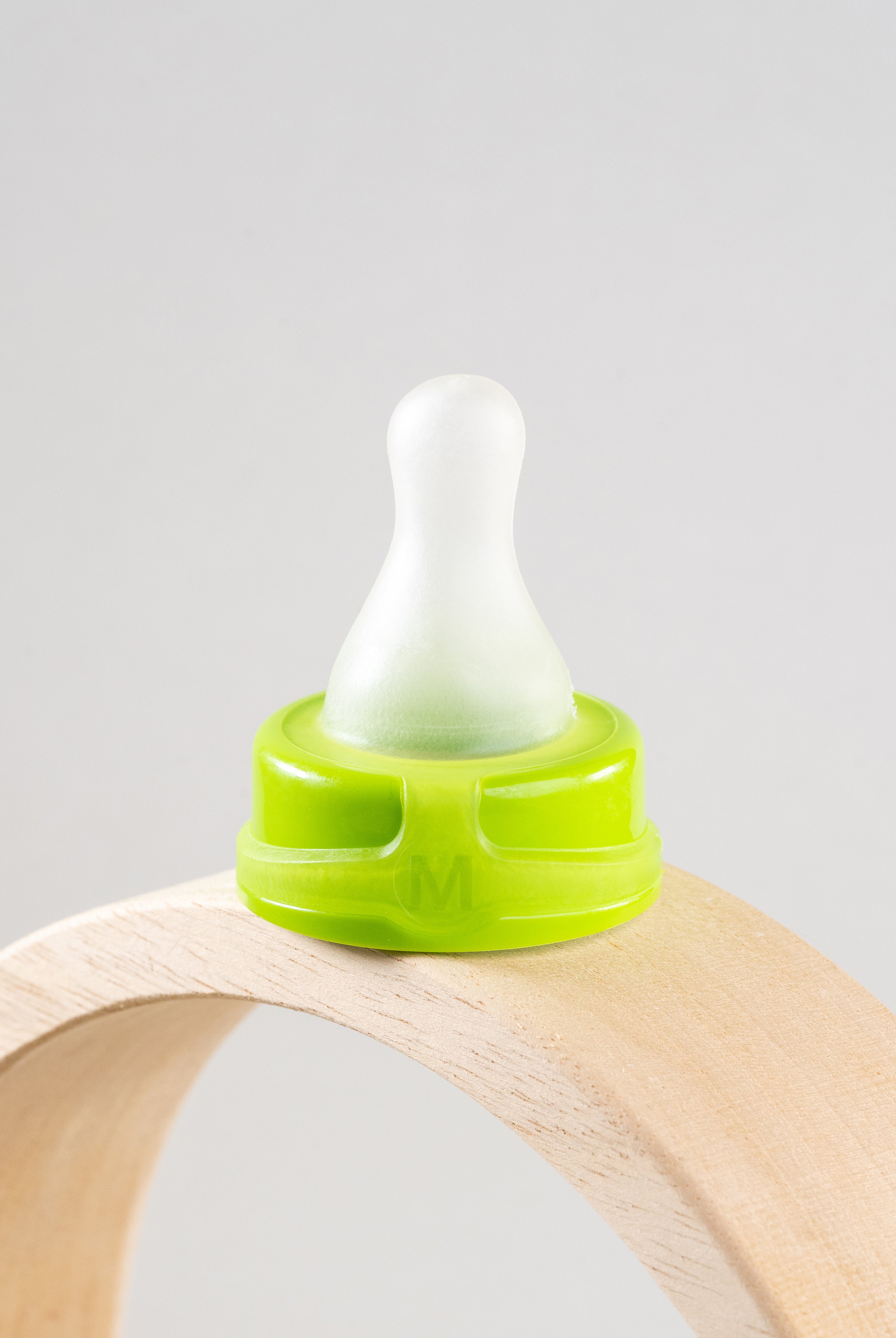 Sepal green medium teat slow flow displayed on wooden arch.