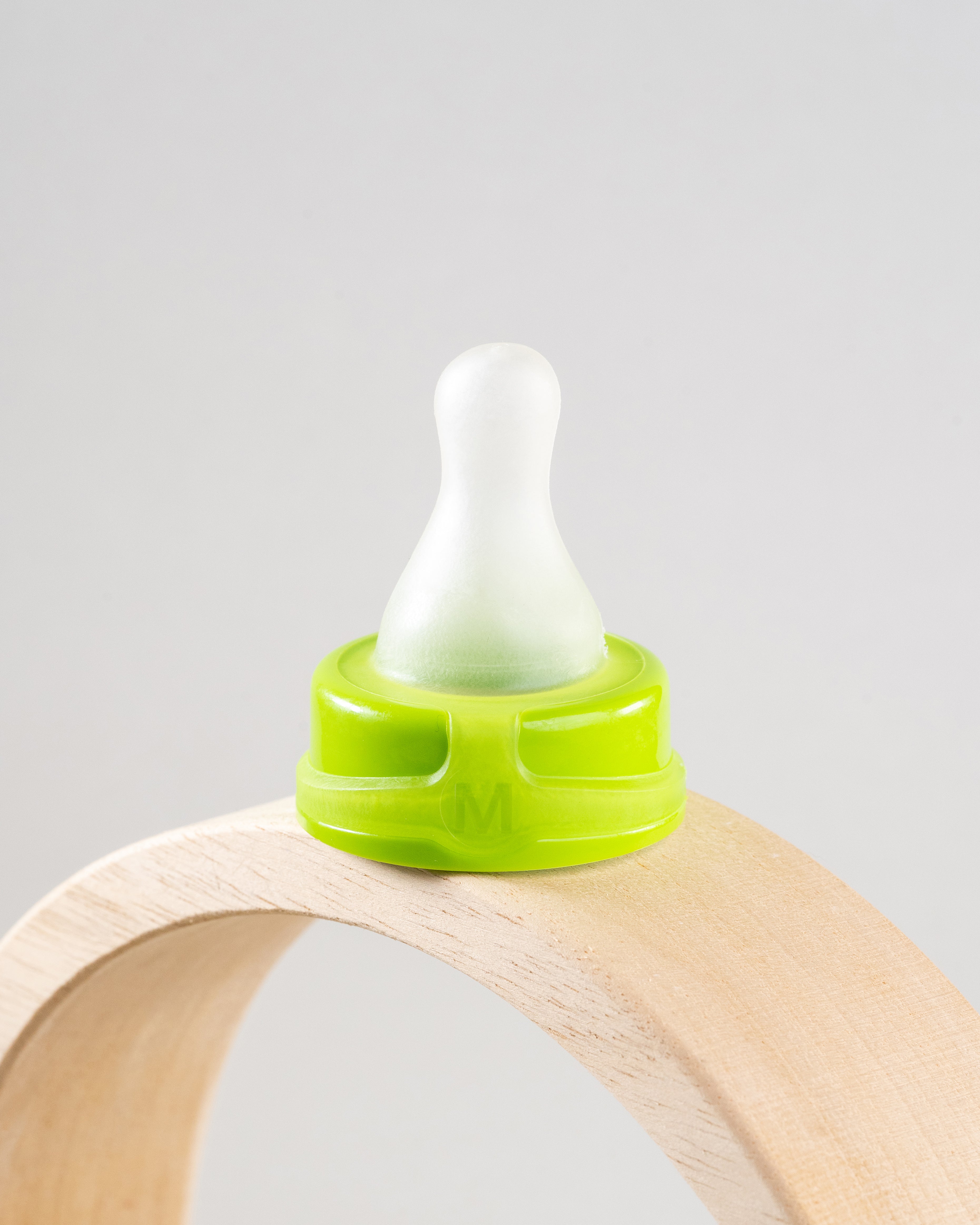 Sepal green medium teat slow flow displayed on wooden arch.