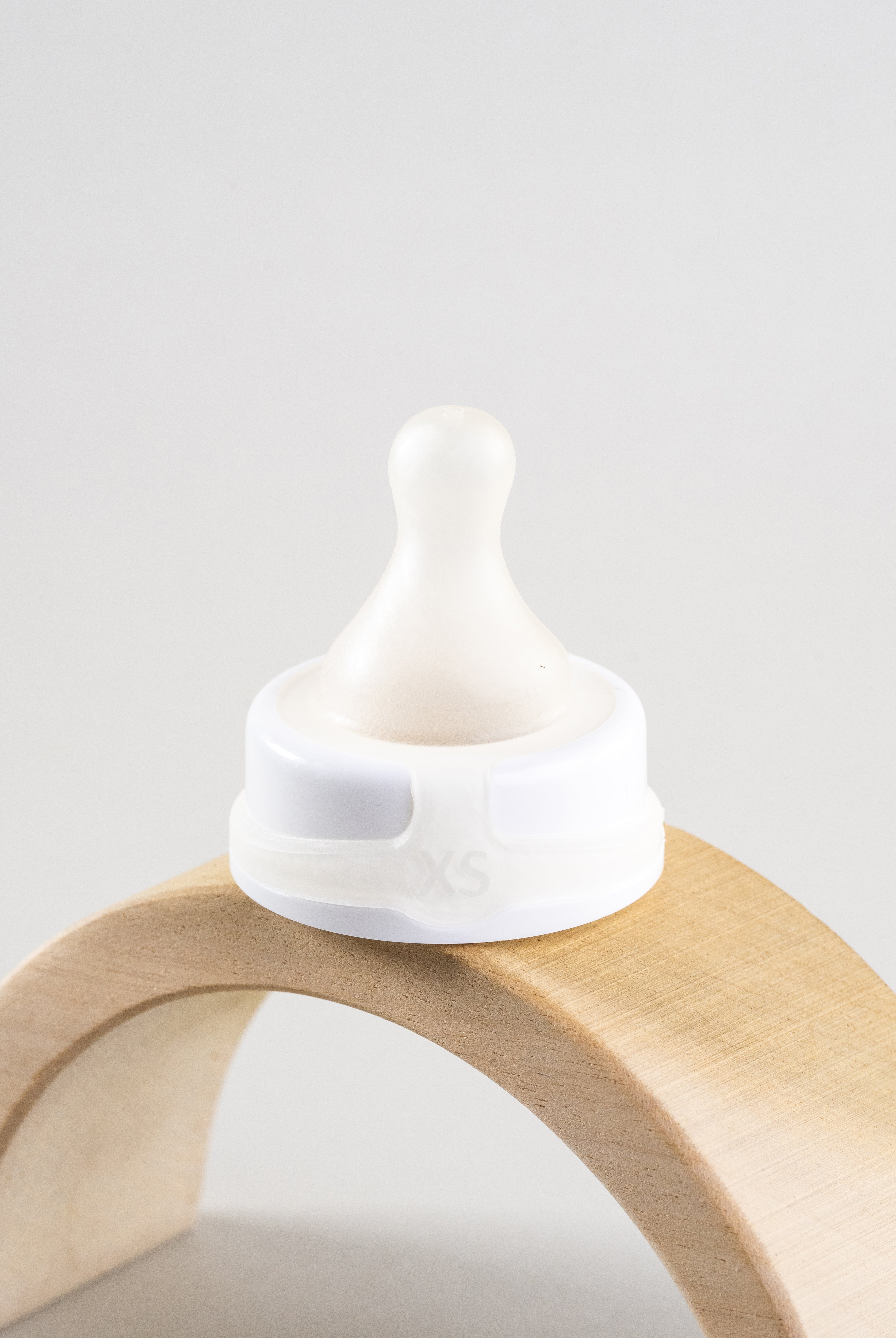 Sepal white extra small teat ultra slow flow. Displayed on a wooden arch.