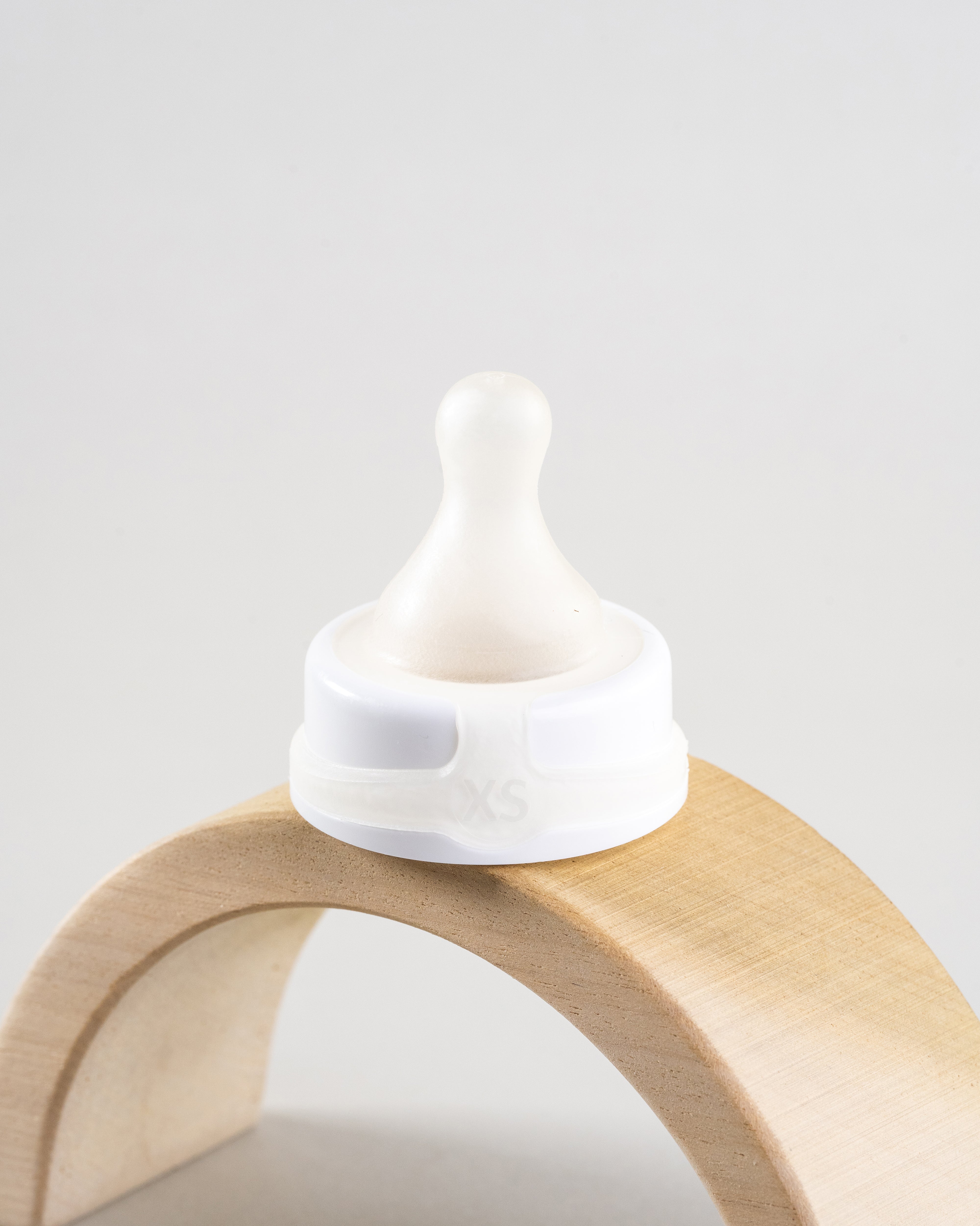 Sepal white extra small teat ultra slow flow. Displayed on a wooden arch.