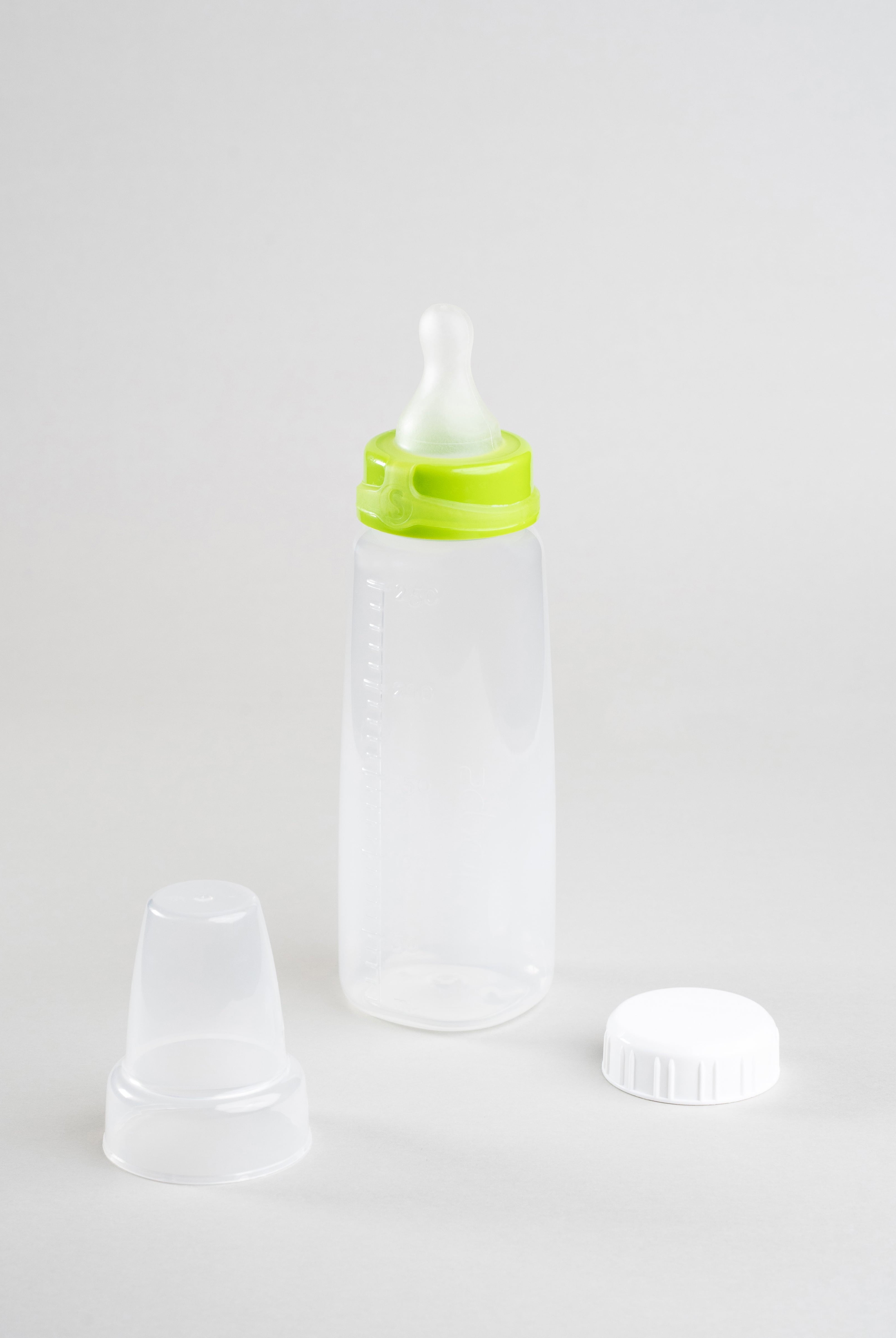 Sepal 250ml bottle with green small teat slow flow attached. Beside this is a Sepal white cap and a clear Sepal Teat Cover.