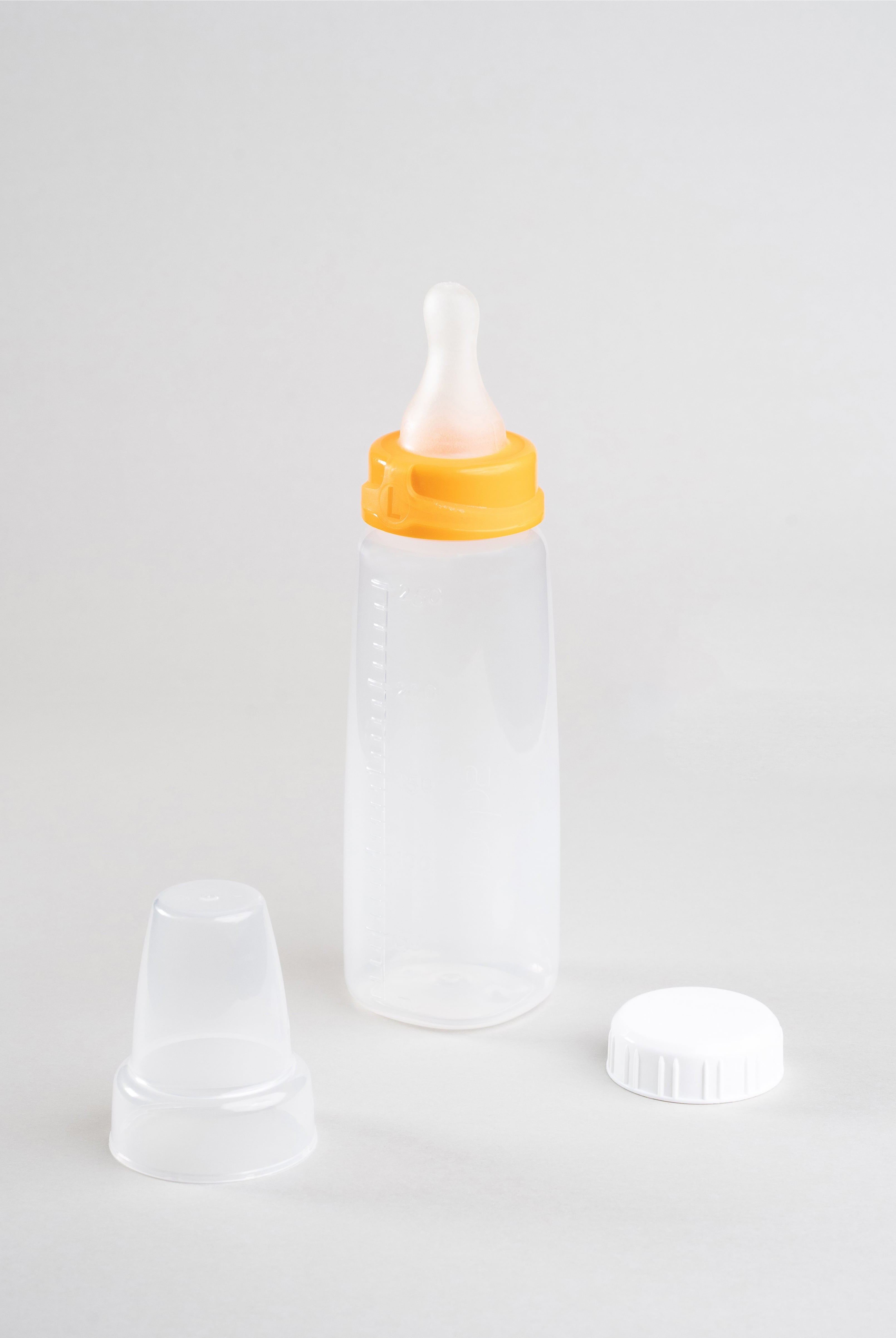 250ml Sepal baby bottle with orange large teat fast flow attached. Beside the bottle is a Sepal white cap and a clear Sepal teat cover.
