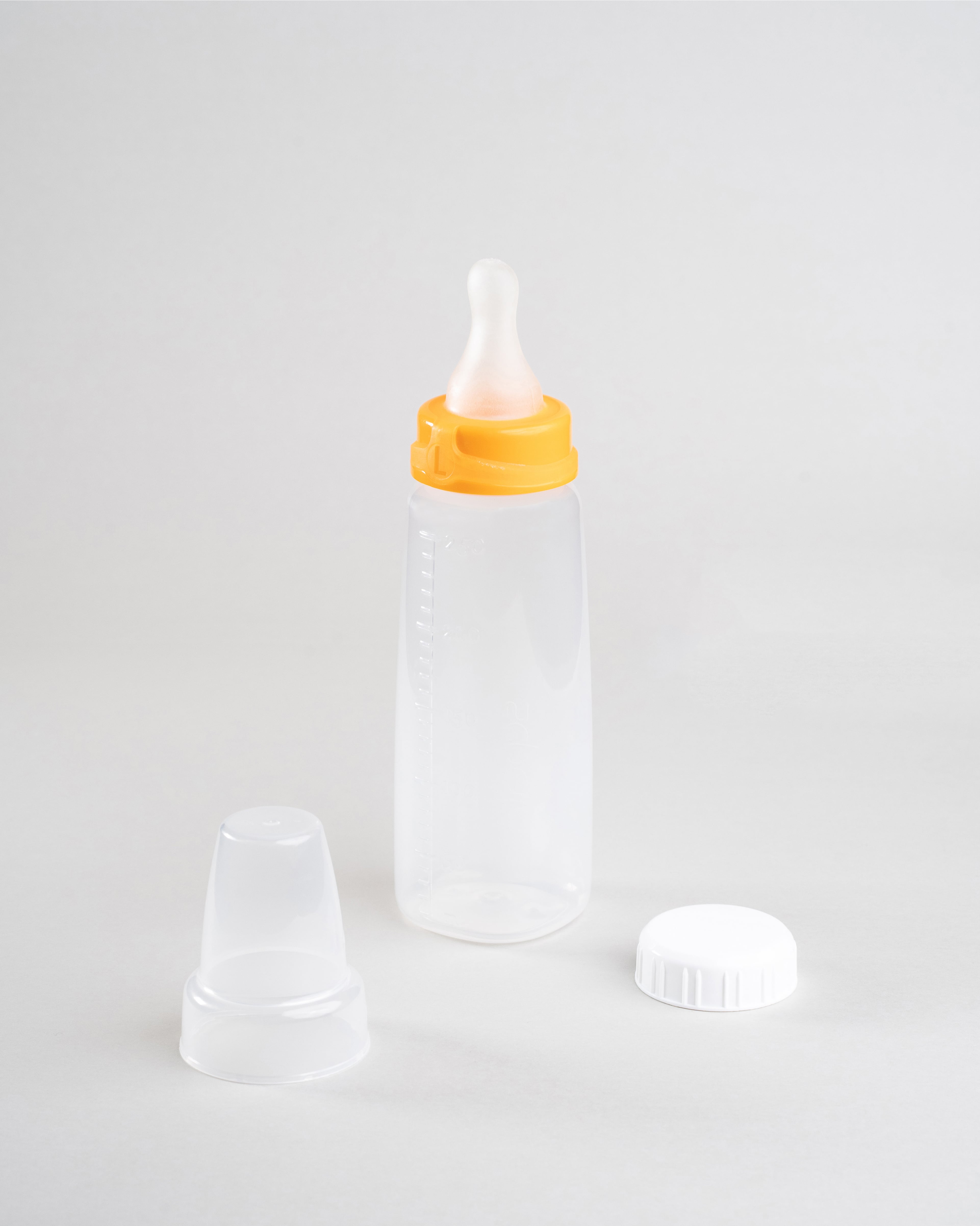 250ml Sepal baby bottle with orange large teat fast flow attached. Beside the bottle is a Sepal white cap and a clear Sepal teat cover.
