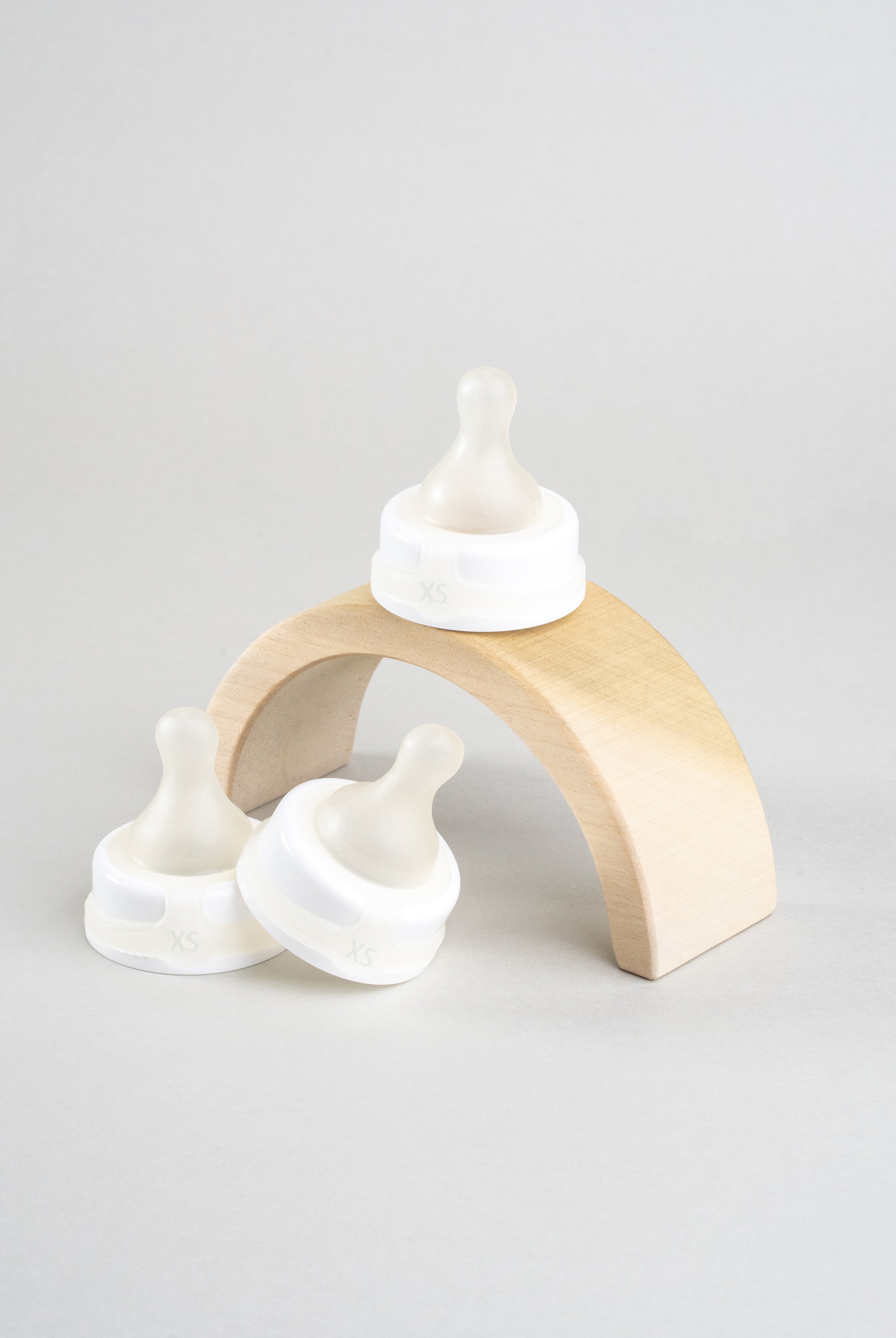 3 Sepal white extra small ultra slow flow teats. Displayed on a wooden arch.