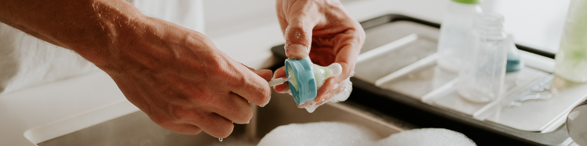 sink with hands cleaning a sepal teat using a teat cleaner