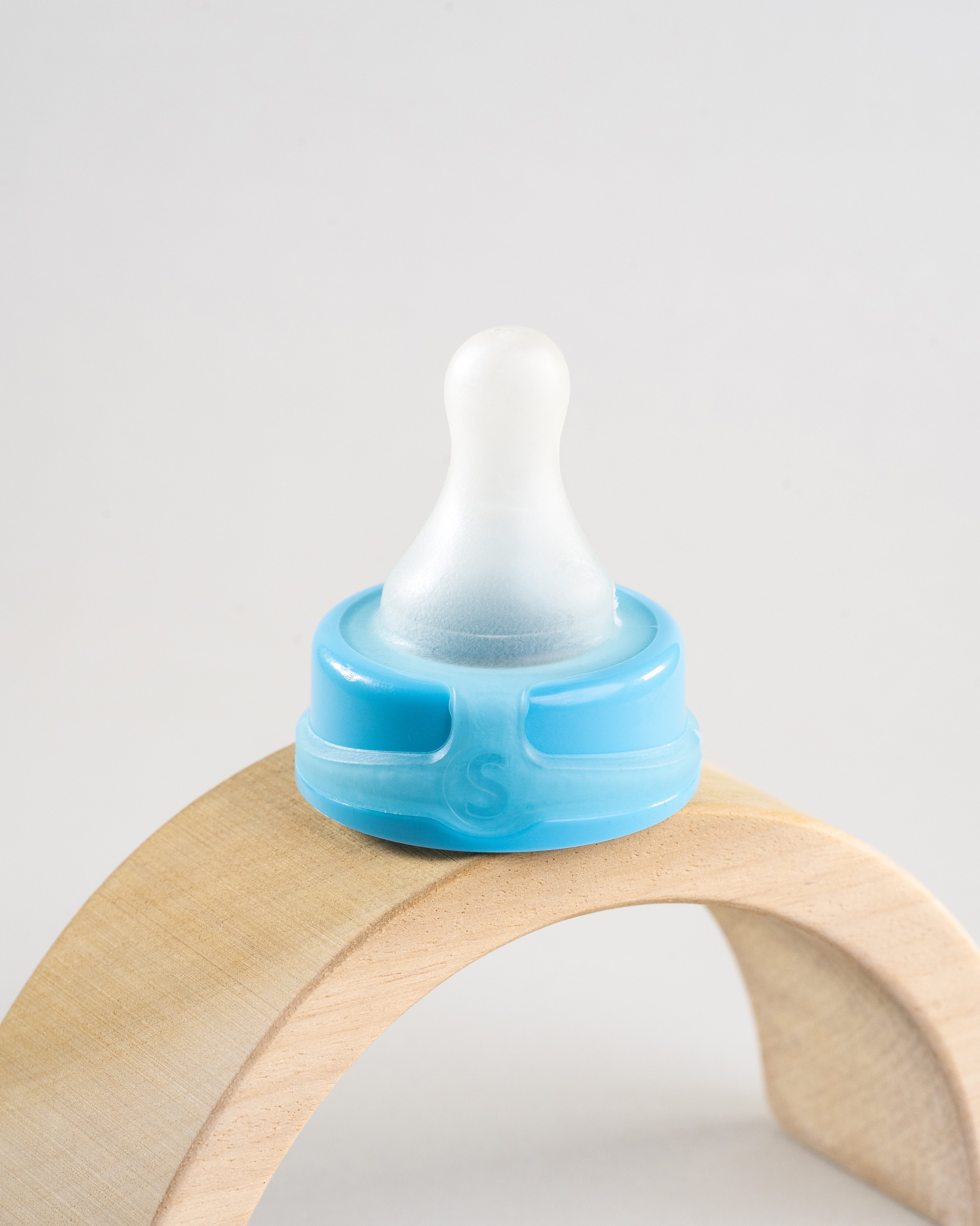 Sepal blue small teat extra slow flow displayed on a wooden arch