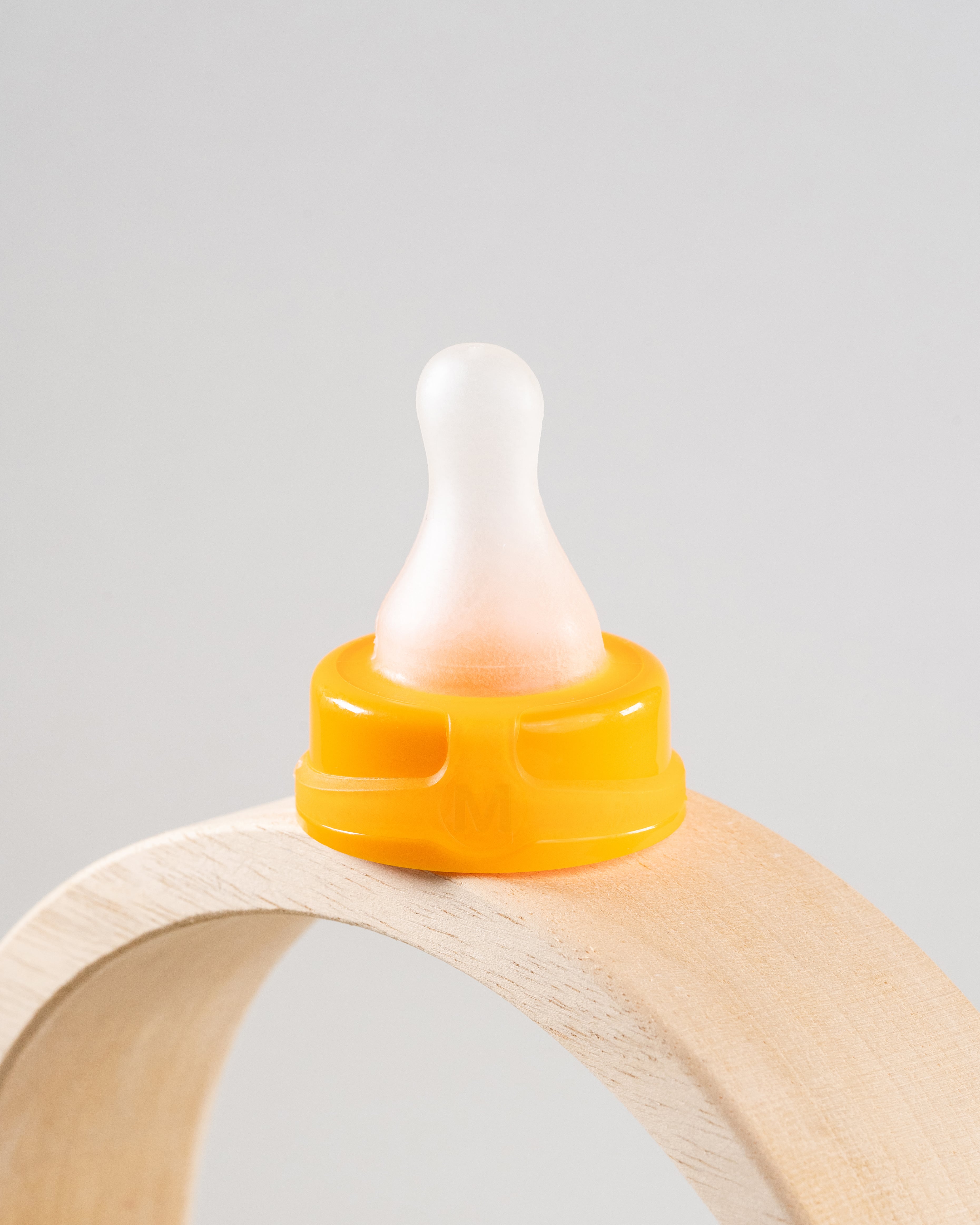 Sepal orange medium teat fast flow displayed on a wooden arch. 