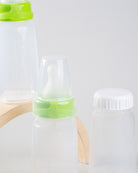 Close up photo of 2 sepal green small teat slow flow, 1 sepal white cap, 1 sepal clear teat cover and 3 sepal 150ml bottles