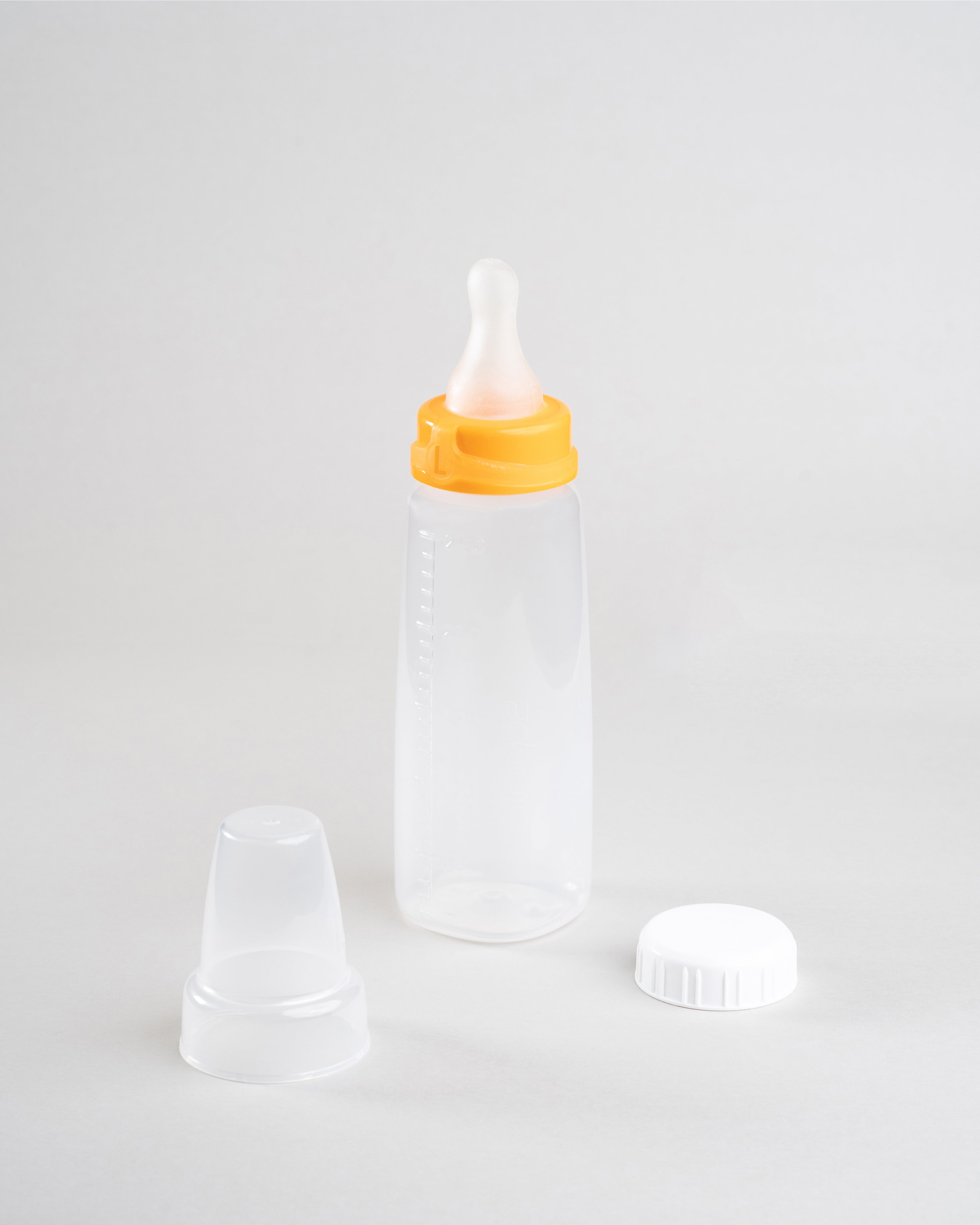 250ml Sepal baby bottle with orange large teat fast flow attached. Beside the bottle is a Sepal white cap and a clear Sepal teat cover. 